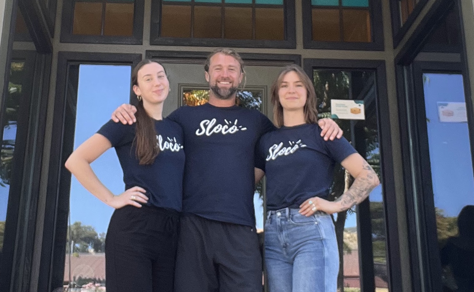 Sloco Health + Wellness team members jumping for joy in front of wellness center in San Luis Obispo